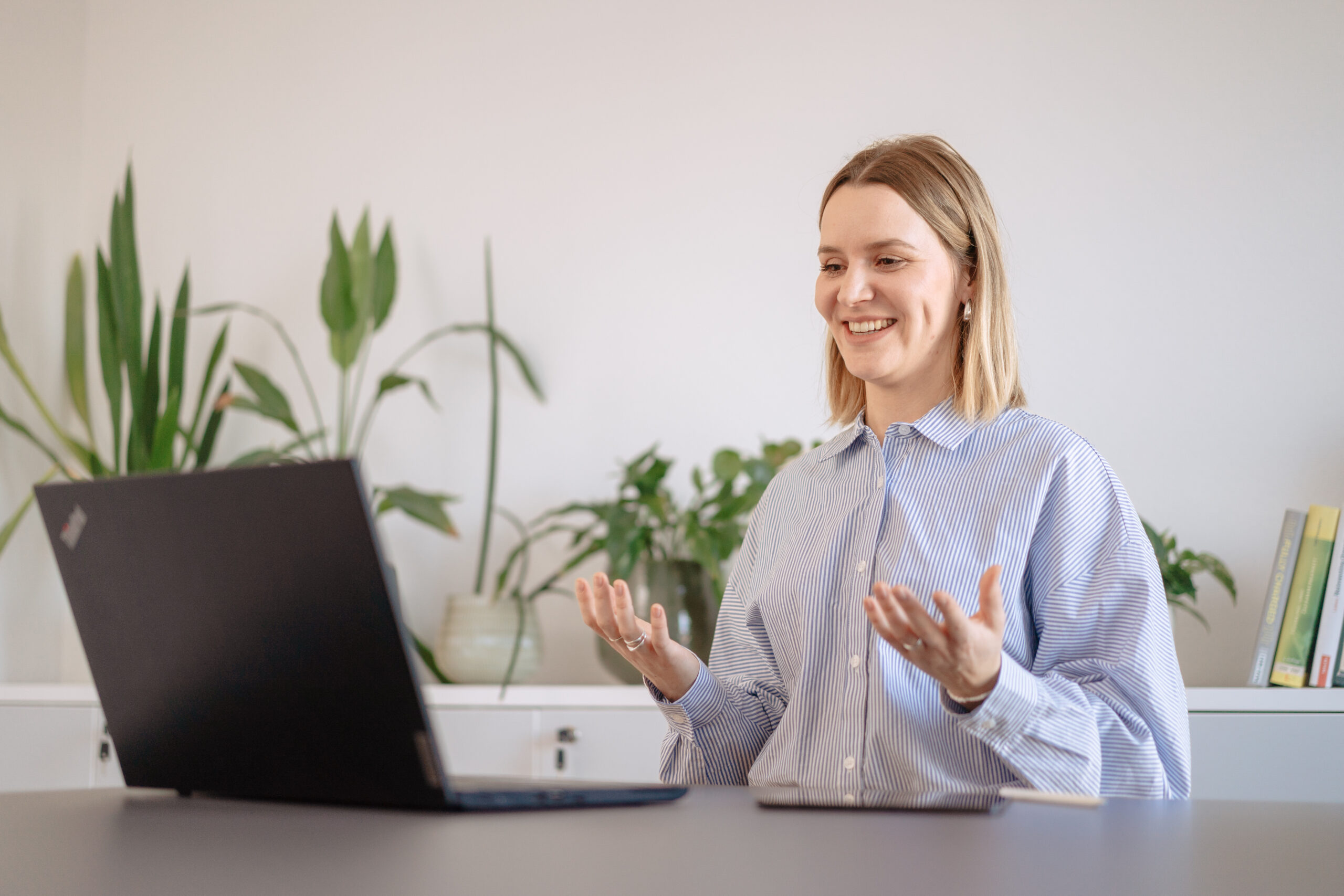 Ankündigung Impulse Call Speakerin steht vor einem Laptop und erzählt in einem virtuellen Call einer Gruppe von Interessierten zu einem relevanten, zukunftsgerichteten Thema