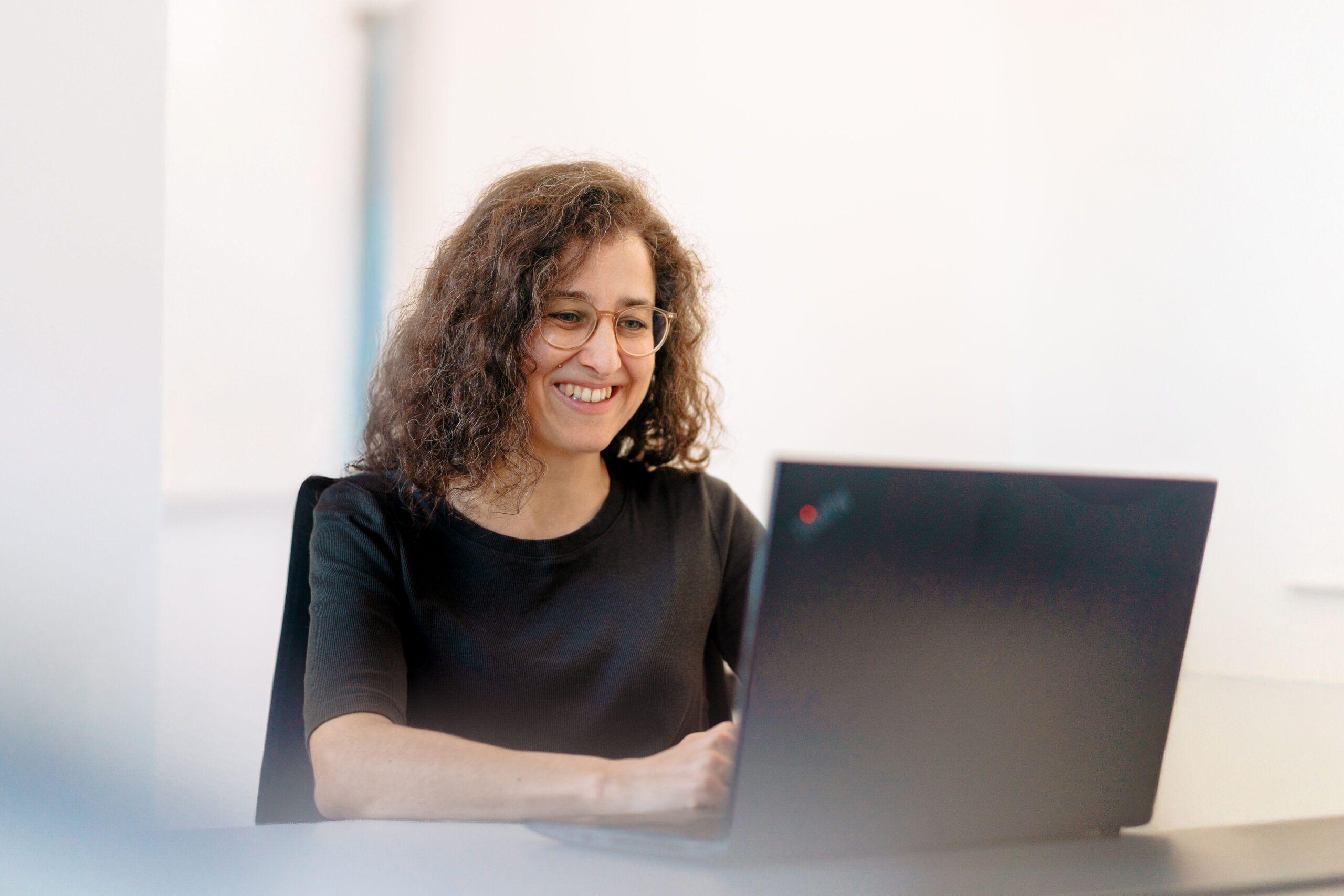 Produktübersicht Vielfältige Tools, individuelle Lösungen, digitale Formate, unsere Produkte unterstützen Personalentwicklung und Organisationsgestaltung praxisnah und effektiv, Frau sitzt lachend vor einem Laptop